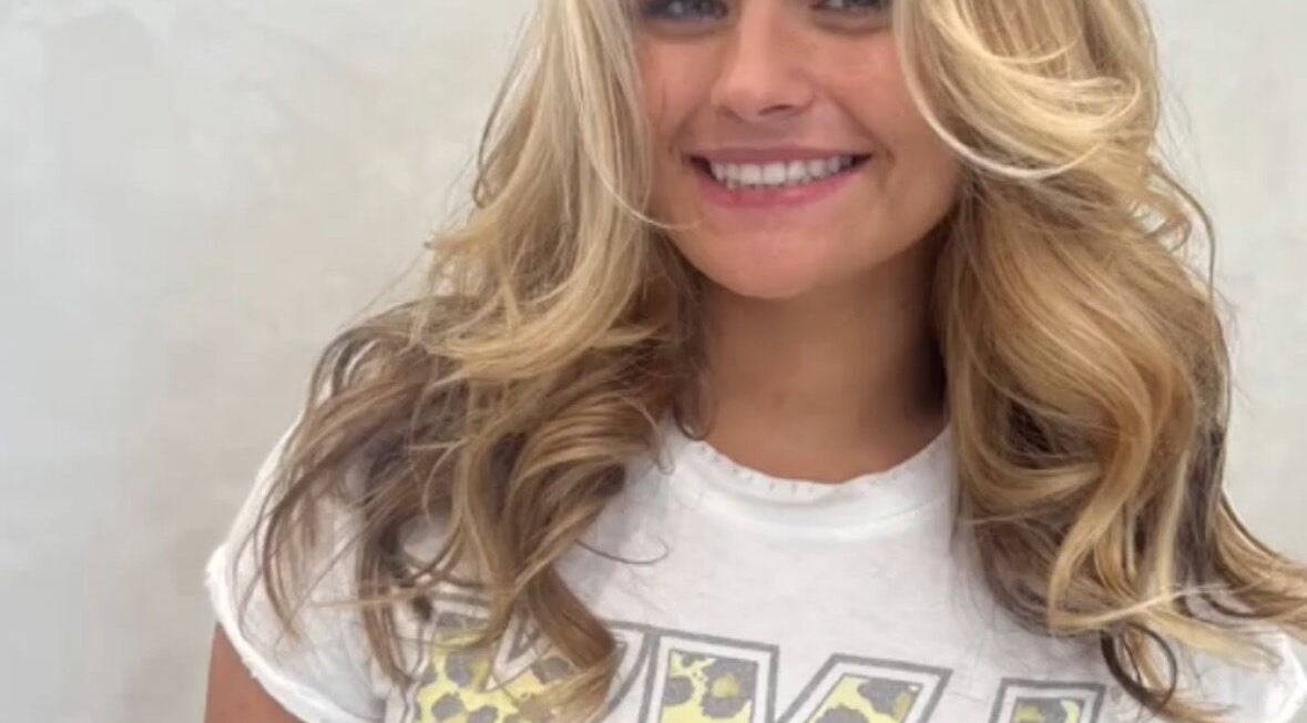 Smiling person with styled blonde hair at Holly Fitzgibbon salon, Boca Raton, Florida, US.