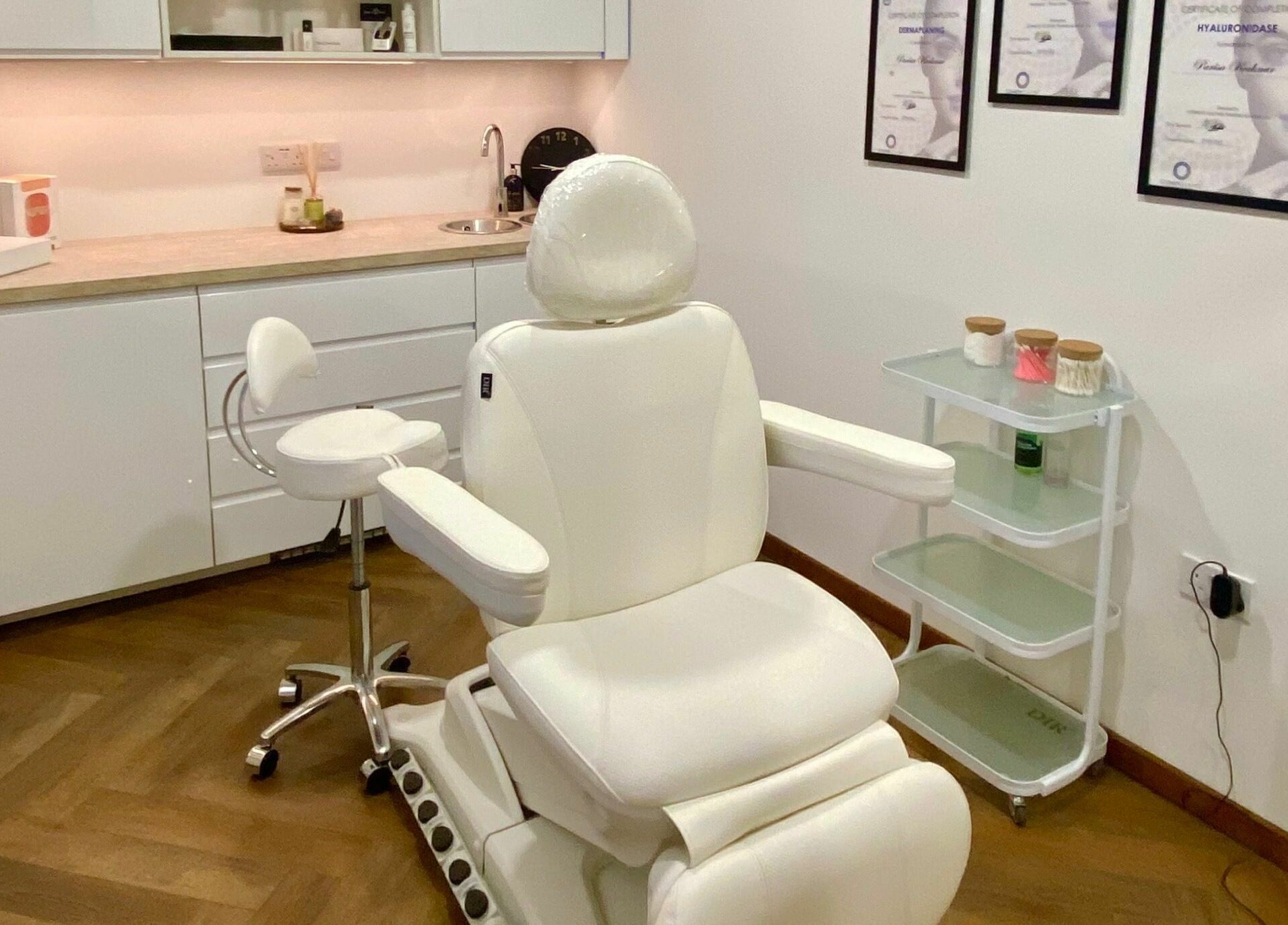 Luxurious treatment room at PK Aesthetic in Glasgow, Scotland, GB, featuring a white reclining chair and stylish decor.