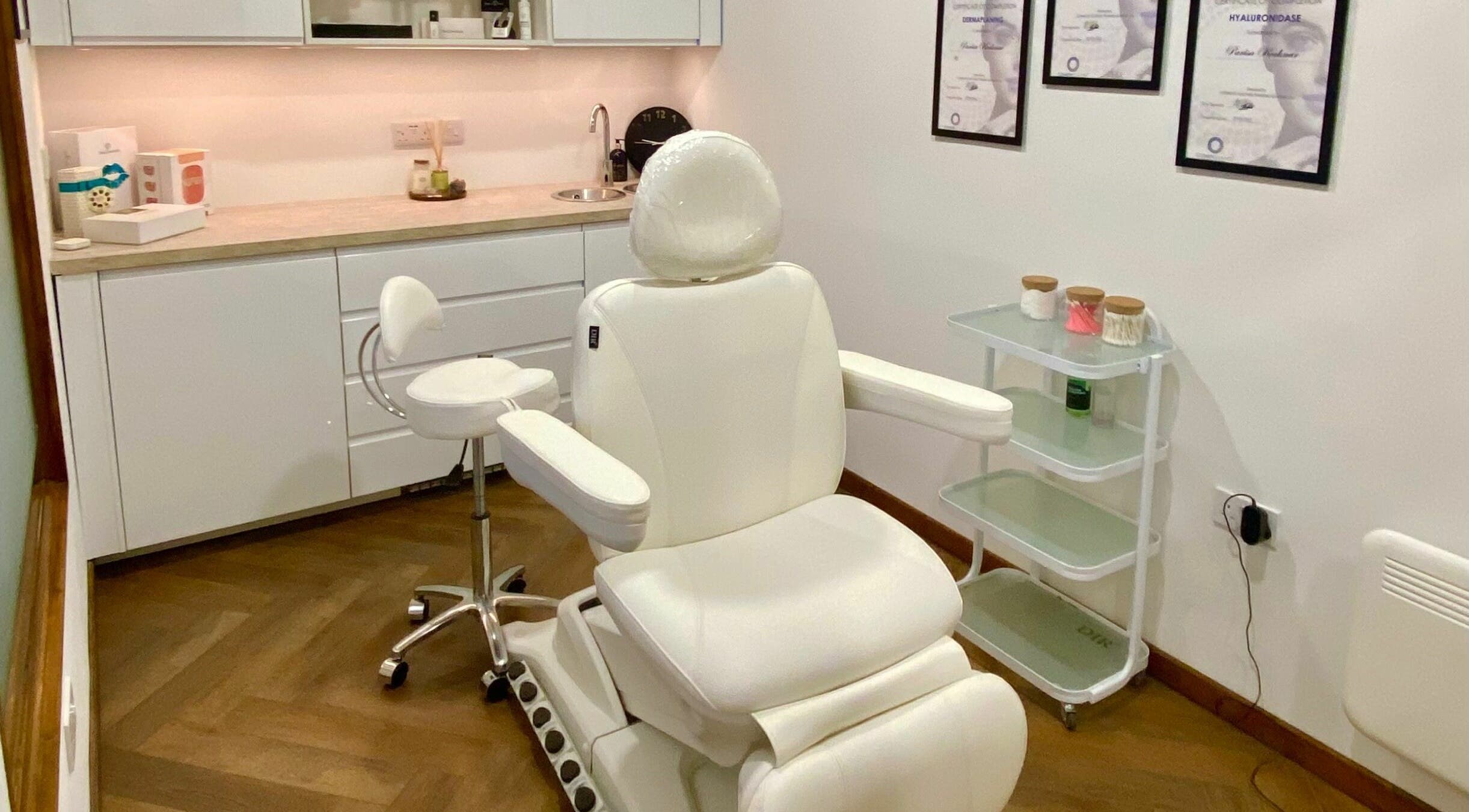 Luxurious treatment room at PK Aesthetic in Glasgow, Scotland, GB, featuring a white reclining chair and stylish decor.