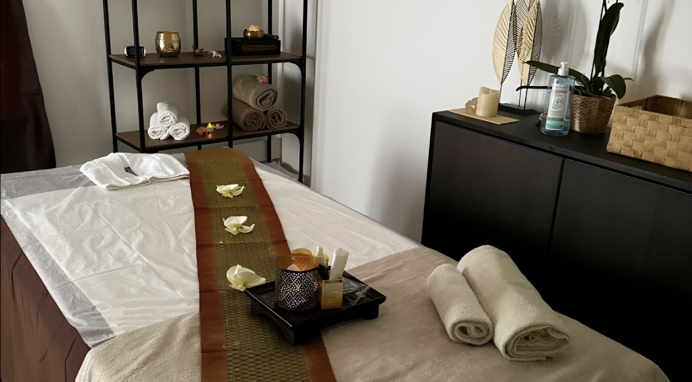 Table de massage paisible à Sao Zen Chessy, Chessy, Île-de-France, FR, avec serviettes pliées et décor raffiné.