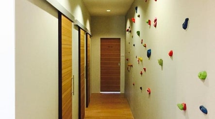 Bright hallway with wooden doors and colorful rock accents at Bangkok Sports Massage Thonglor, Wattana, Bangkok, TH.