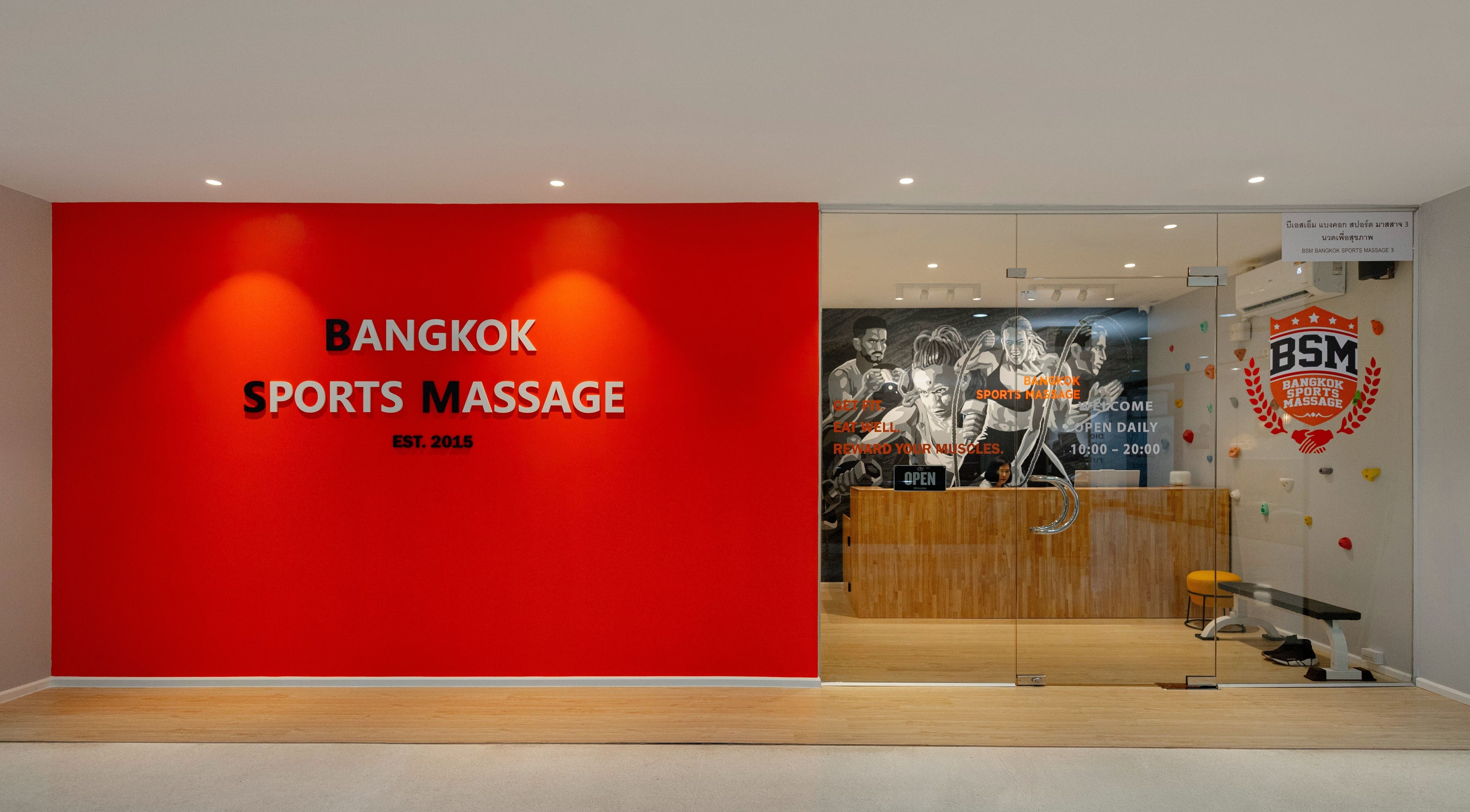 Entrance of Bangkok Sports Massage Silom in Bangrak, Bangkok with bold red wall and logo.