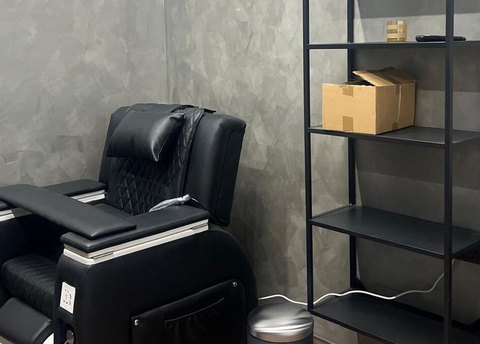 Chic black massage chair and shelving at Le Mirage, Doha, Doha Municipality, QA for ultimate relaxation.