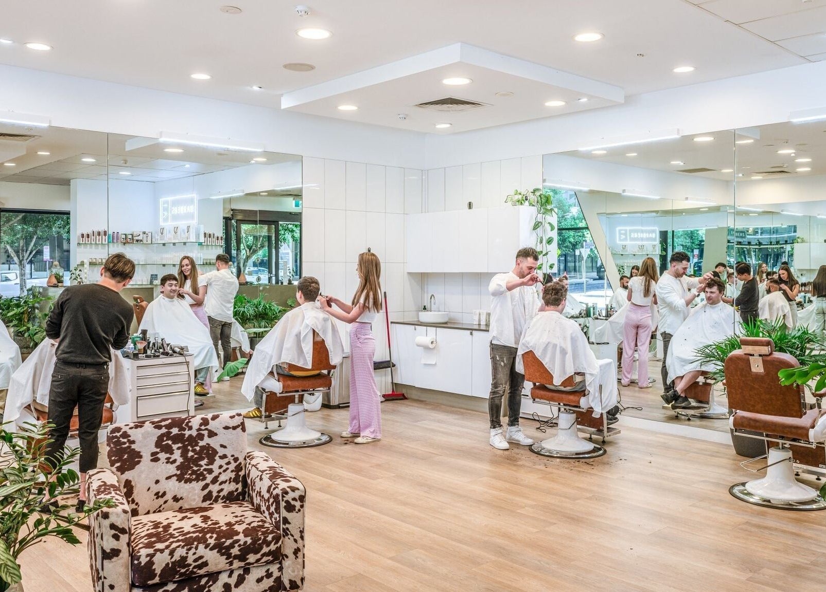 IV Barbers in Melbourne, Victoria, AU features a vibrant salon with customers enjoying haircuts.