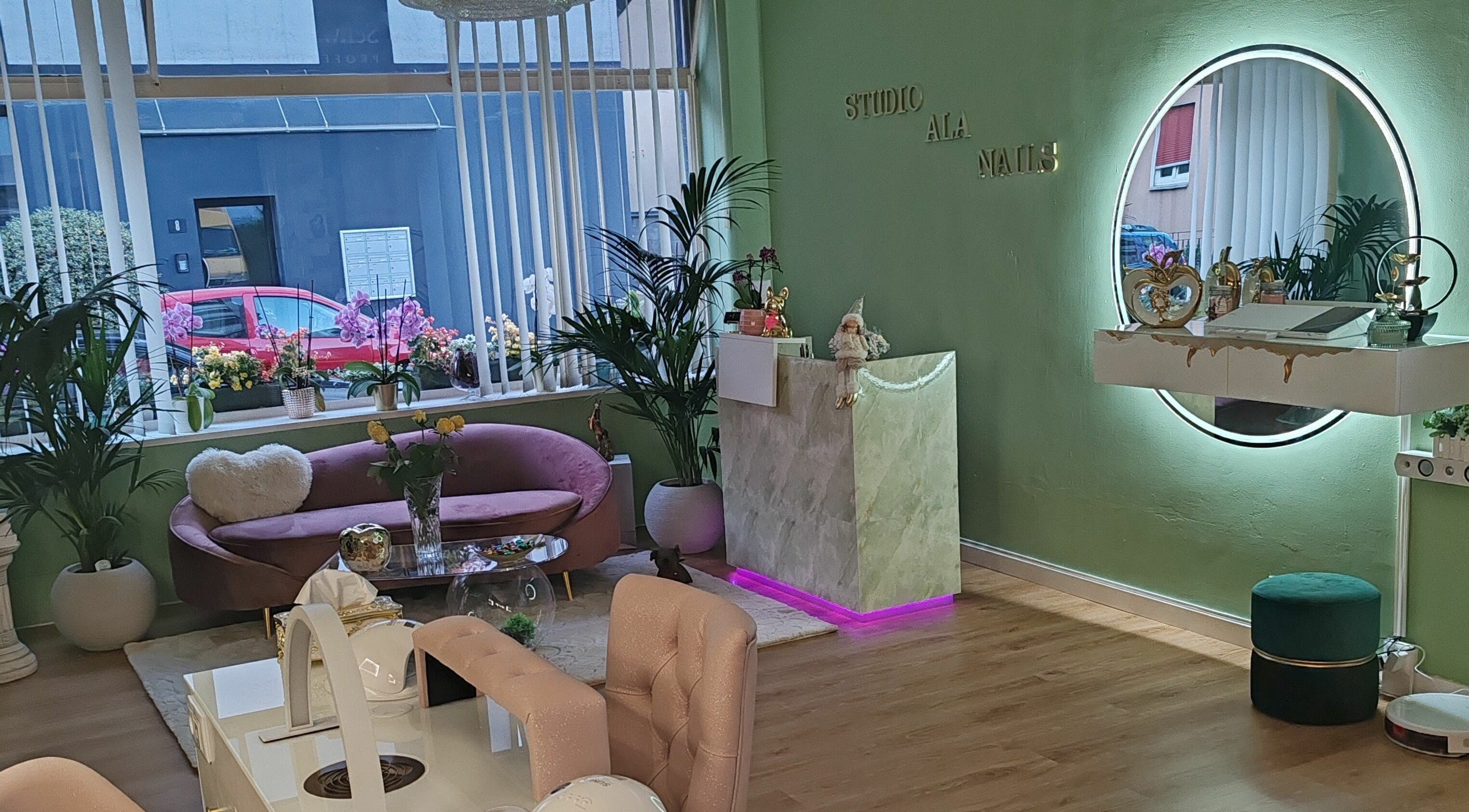 Interno elegante con divano e specchio ad Ala Nails Studio, Lugano, Ticino, CH, perfetto per relax e bellezza.