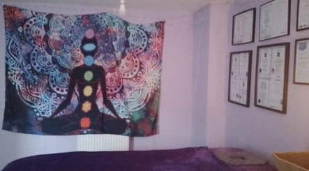 Colorful chakra tapestry and framed certificates at Release and Re-ignight Homebased Clinic, Keighley, England, GB.