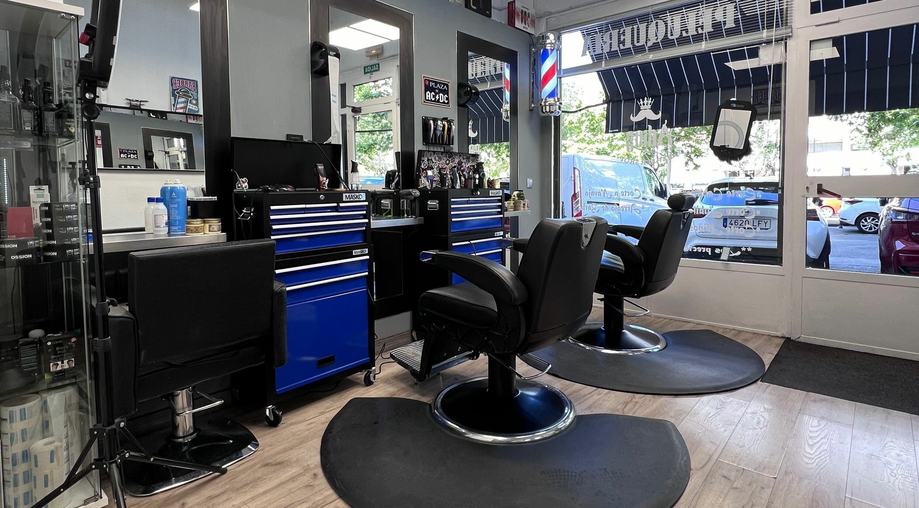 Interior de Akios barber shop en Madrid, Comunidad De Madrid, ES, con sillas negras y herramientas de peluquería.