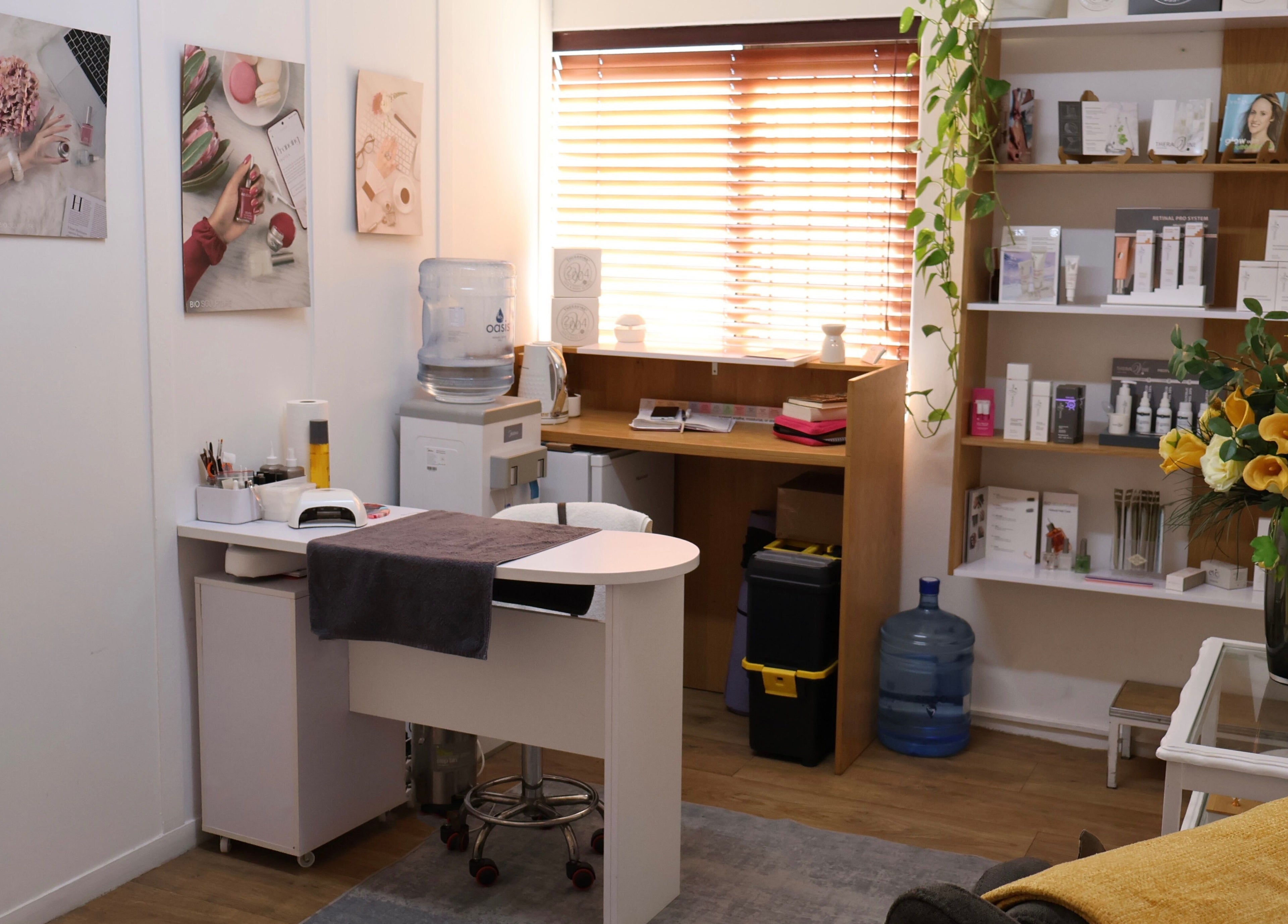 Lindsay Jordaan Beauty Boutique's cozy interior in Cape Town, Western Cape, ZA with treatment desk and floral decor.