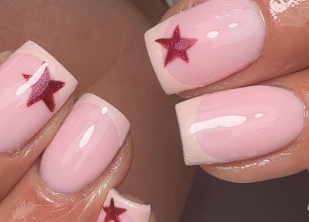 Elegant pink nails with red star designs at Bymolh, Lichfield, England, GB. A chic beauty manicure.