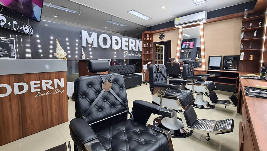Interior elegante de Modern Barber Shop en Yopal, Casanare, CO, con sillones negros y decoración sofisticada.