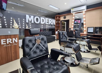 Interior elegante de Modern Barber Shop en Yopal, Casanare, CO, con sillones negros y decoración sofisticada.