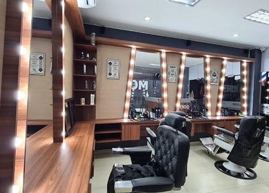 Interior de Modern Barber Shop en Yopal, Casanare, CO, con sillas elegantes y espejos iluminados.