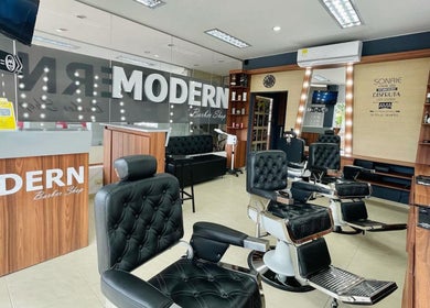 Interior de Modern Barber Shop en Yopal, Casanare, CO, mostrando sillones de peluquería y decoración elegante.