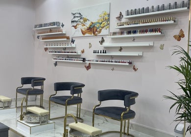 Luxurious pedicure chairs at Toplist Nail Beauty Salon in Dubai, Dubai, AE with colorful nail polish display.