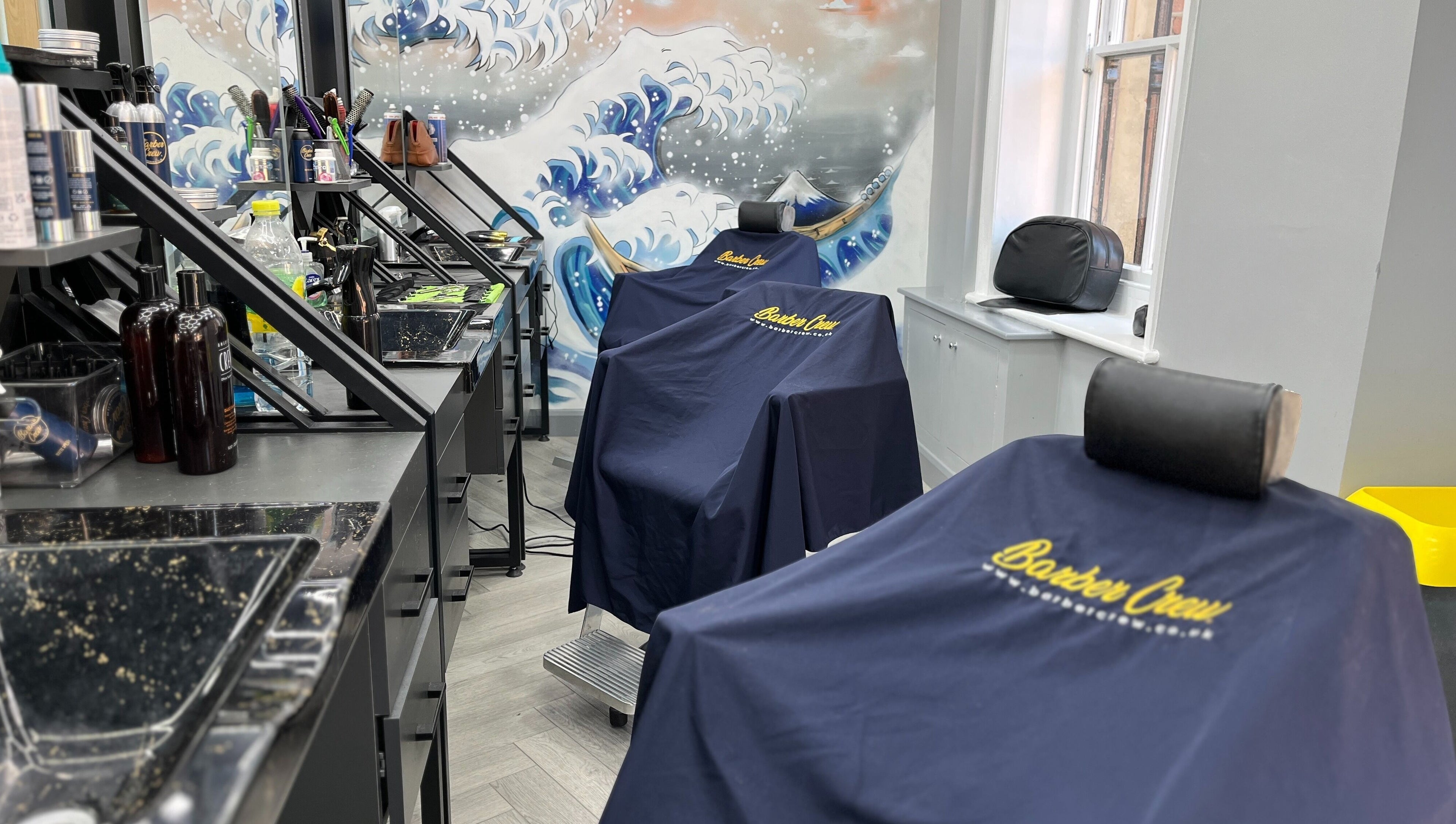 Barber chairs with branded covers at Barber Crew Wokingham, Wokingham, England, GB, showcasing professional setup.