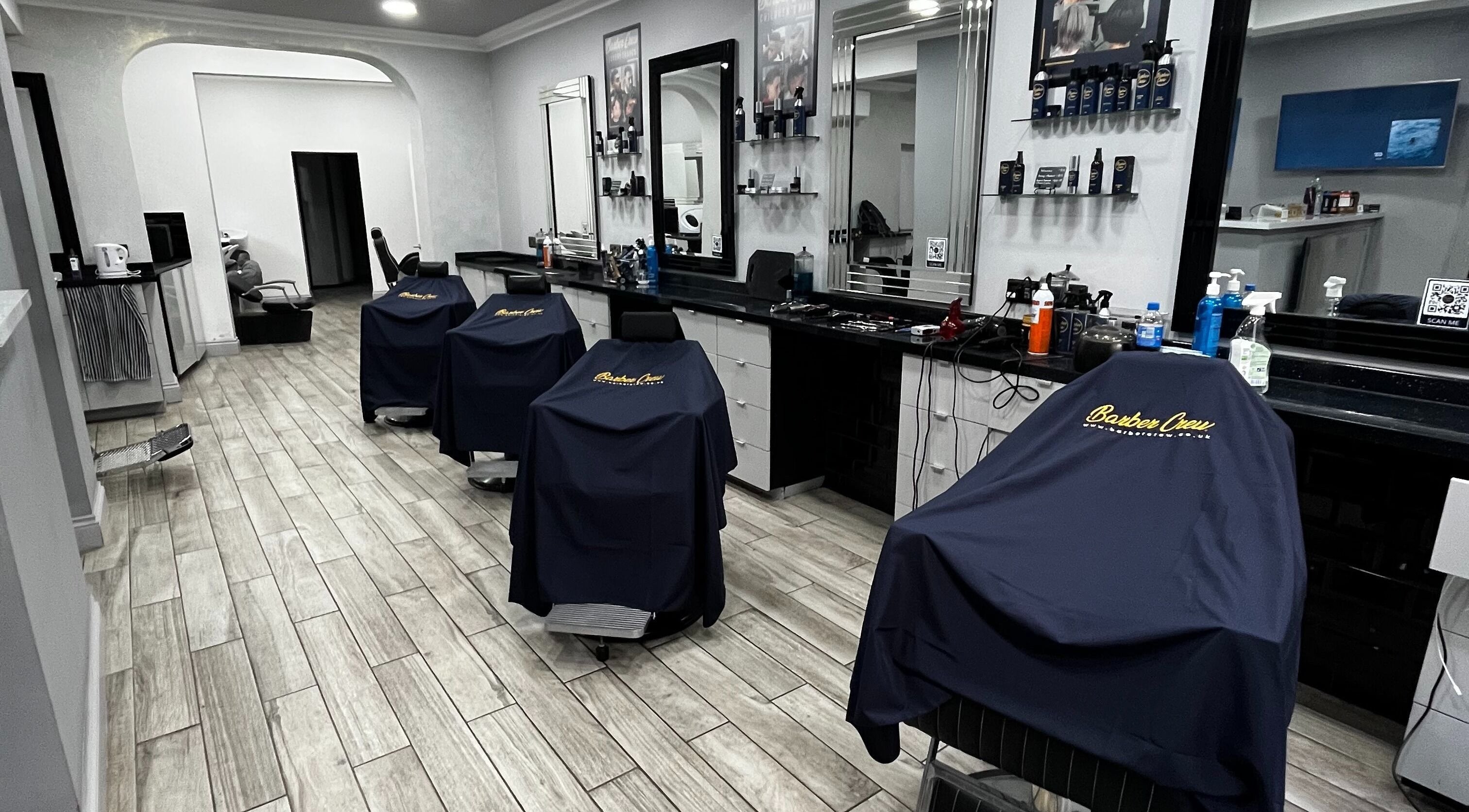 Modern barber chairs in Barber Crew Twyford, Twyford, England, GB, featuring sleek interior design.