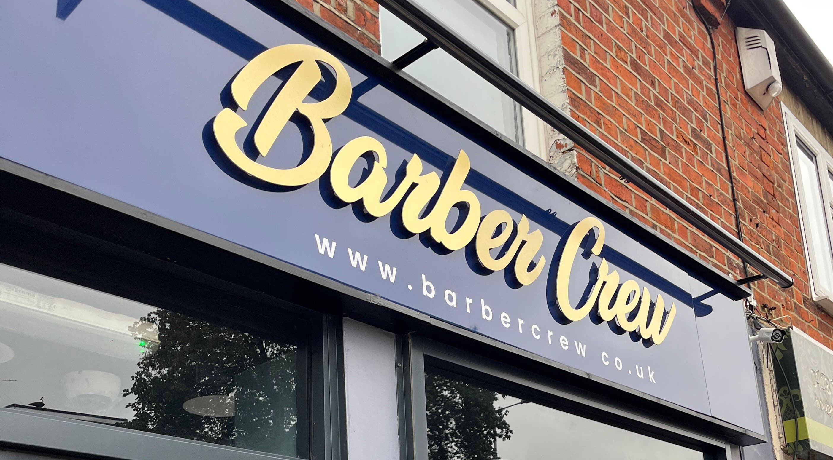 Exterior signage of Barber Crew Earley in Reading, England, GB showcasing its bold and stylish logo.