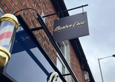 Barber Crew Earley entrance with signboard in Reading, England, GB, featuring a classic barber pole.