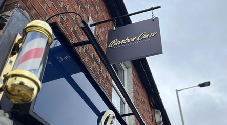 Barber Crew Earley entrance with signboard in Reading, England, GB, featuring a classic barber pole.