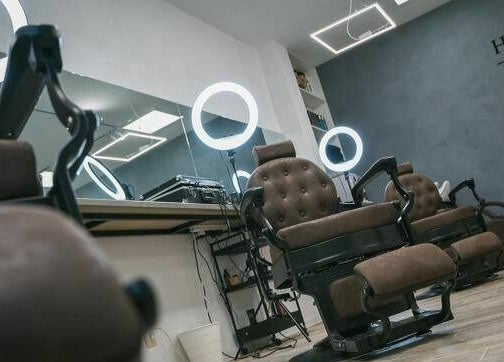 Интериор на Hansel and Gretel Nails & Barber - Debar 19, Varna, Varna, BG. Стилни бръснарски столове и кръгови лампи.