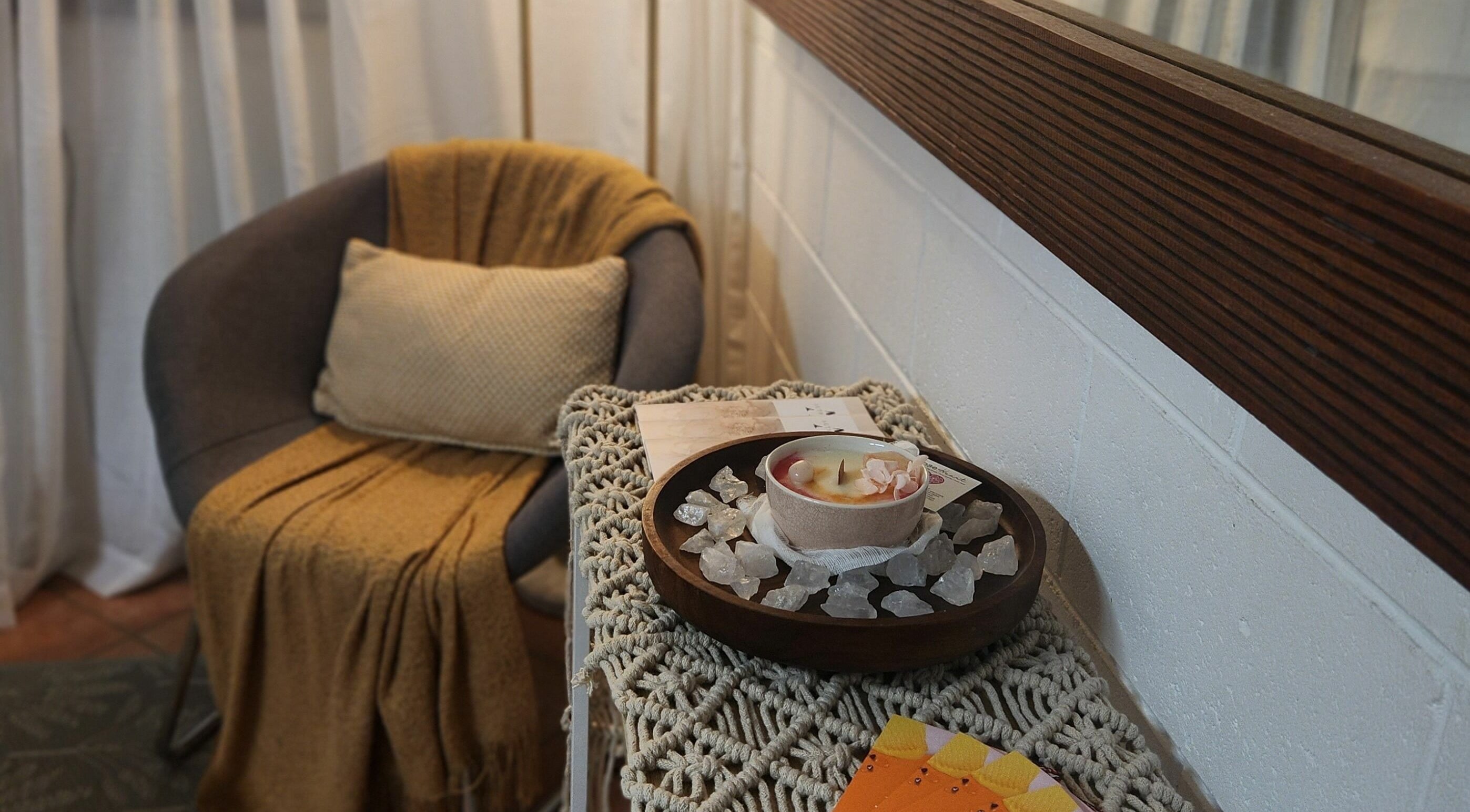 Cozy seating with candle and crystals at Authentic Zen Beauty, New Auckland, Queensland, AU.