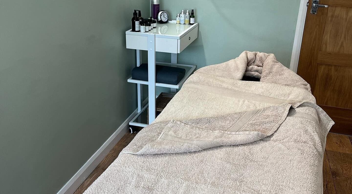Relaxing treatment room at Calm Organic Beauty in Kilgetty, Wales, GB, featuring a cozy massage bed and essentials.