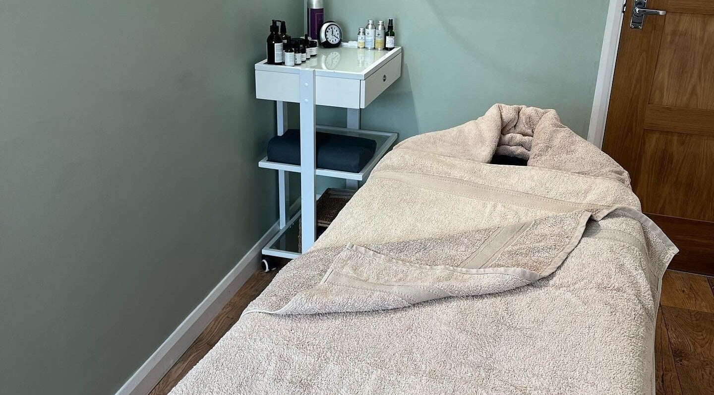Relaxing treatment room at Calm Organic Beauty in Kilgetty, Wales, GB, featuring a cozy massage bed and essentials.