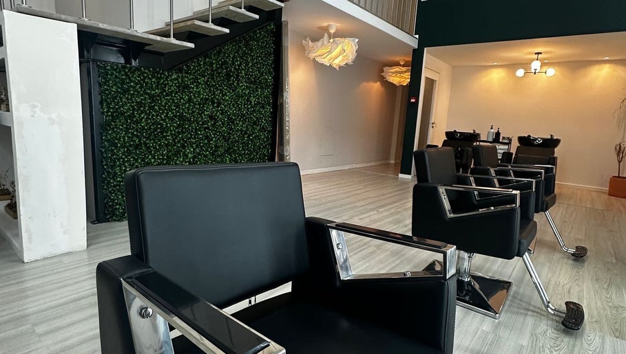 Interior moderno do salão Jaminny Amorim Concept Beauty em Braga, Braga, PT, com cadeiras elegantes e decoração verde.