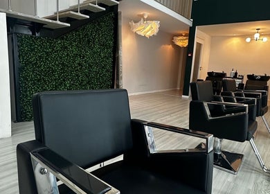 Interior moderno do salão Jaminny Amorim Concept Beauty em Braga, Braga, PT, com cadeiras elegantes e decoração verde.
