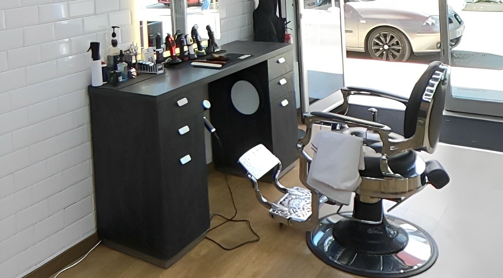 Interior elegante da Nicacio Barber Shop em Braga, Braga, PT, destacando cadeira e bancada de barbeiro.