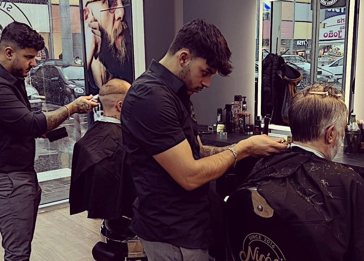 Barbeiros em ação no Nicacio Barber Shop, Braga, Braga, PT, atendendo clientes com precisão.