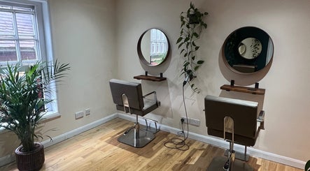 Natural Hair Studio in Horsham, England, showcases a chic, minimalist setup with two styling chairs and mirrors.