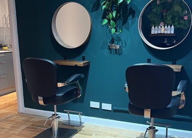 Modern styling station at Natural Hair Studio, Horsham, England, GB, featuring sleek chairs and mirrors.