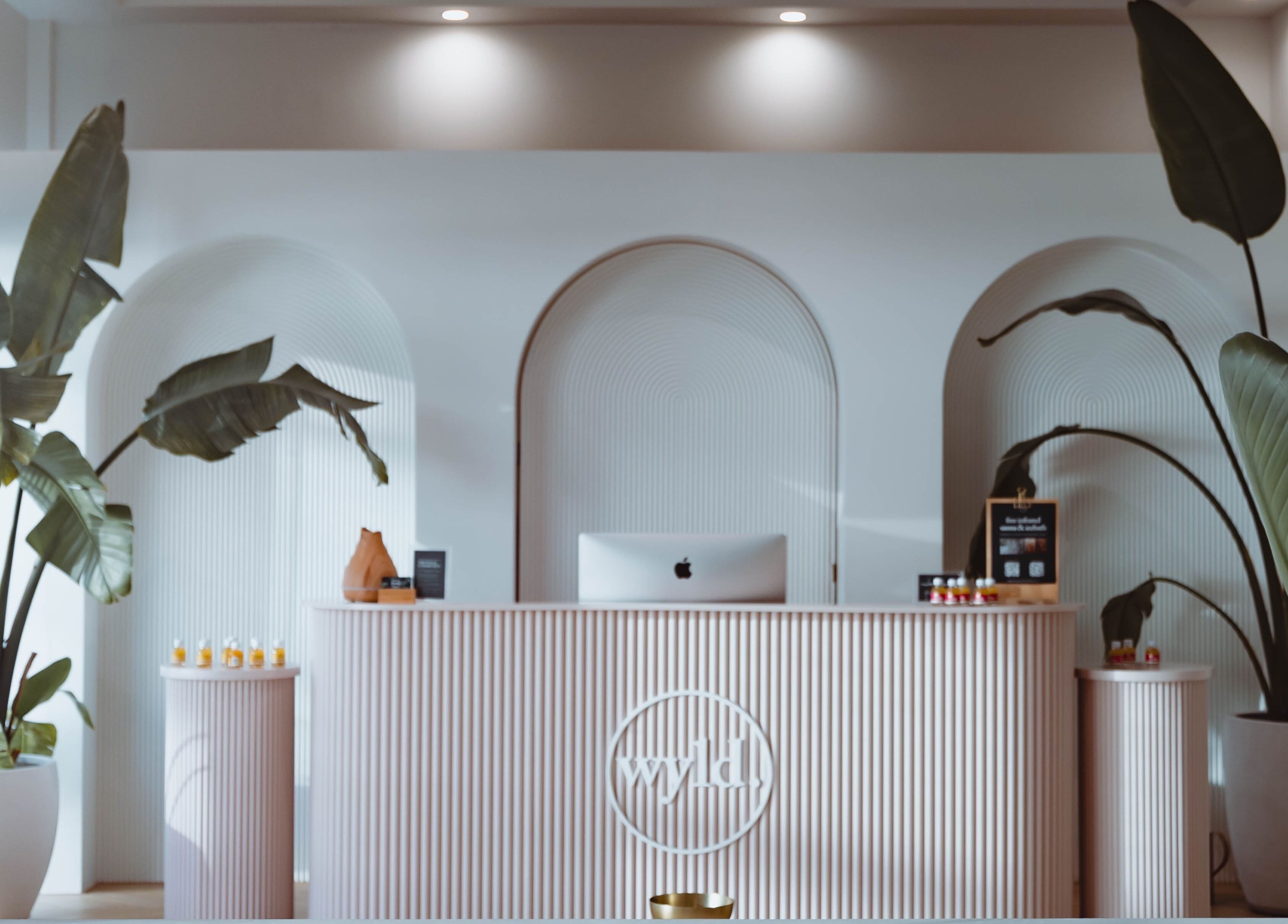 Elegant reception area at WYLD Newmarket, Auckland, NZ showcasing modern design with large green plants.