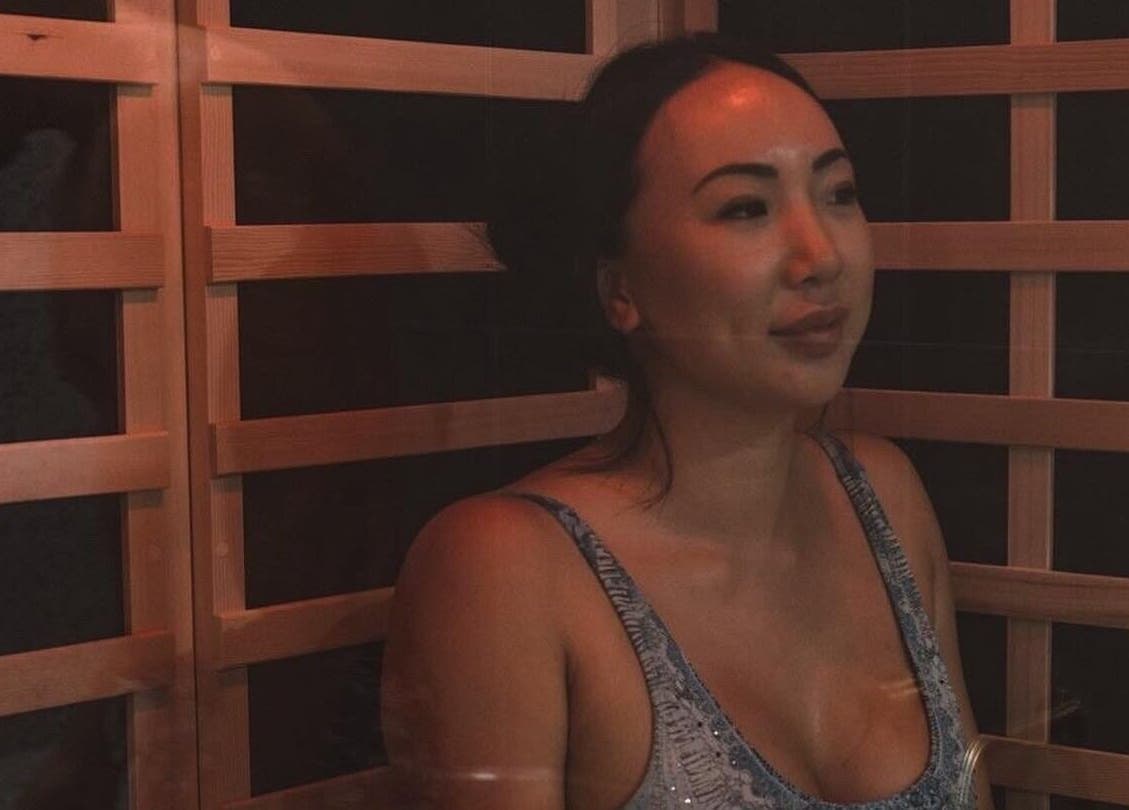 Relaxed woman enjoying sauna at WYLD Howick, Auckland, NZ, highlighting wellness ambiance.