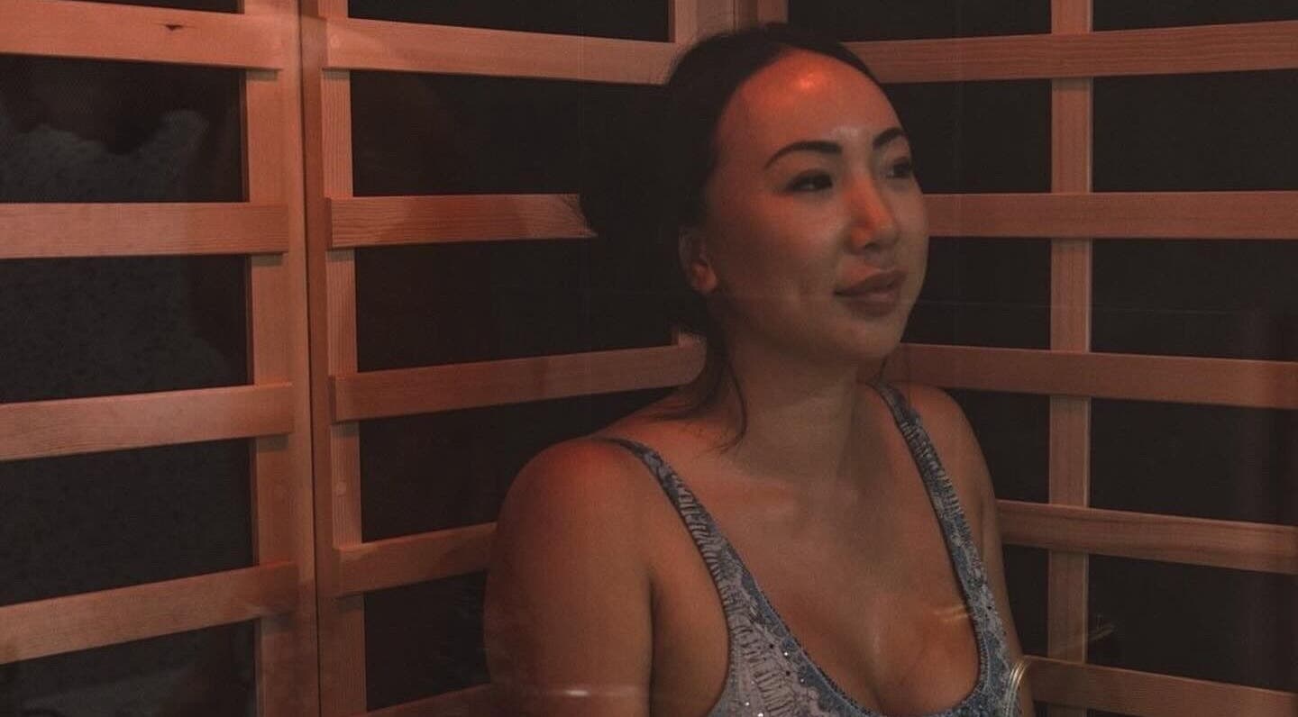 Relaxed woman enjoying sauna at WYLD Howick, Auckland, NZ, highlighting wellness ambiance.
