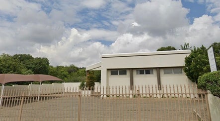 Ozone's sleek exterior in Roodepoort, Gauteng, ZA, with a clear sky backdrop and spacious parking.