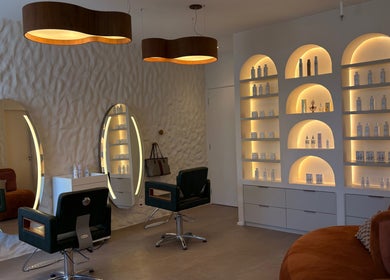 Interior moderno de salão no Dunia Zayed, São Paulo, SP, BR com iluminação elegante e produtos em prateleiras.