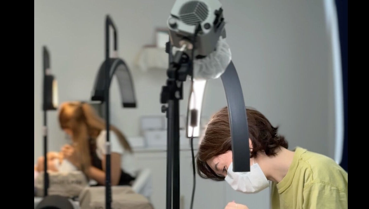 Beauticians performing lash treatments at Brow And Lash Up Bay Ridge, New York, New York, US.