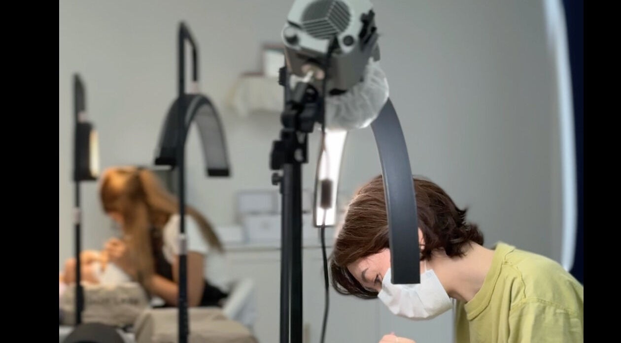 Beauticians performing lash treatments at Brow And Lash Up Bay Ridge, New York, New York, US.