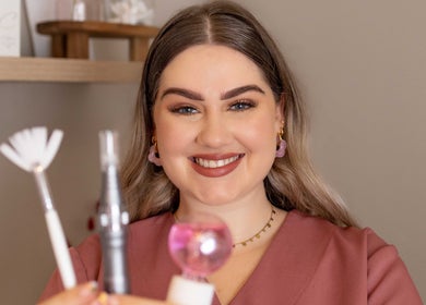 Smiling beauty expert holding skincare tools at By Bianca Skin Studio, Waterfall, Kwazulu-natal, ZA.