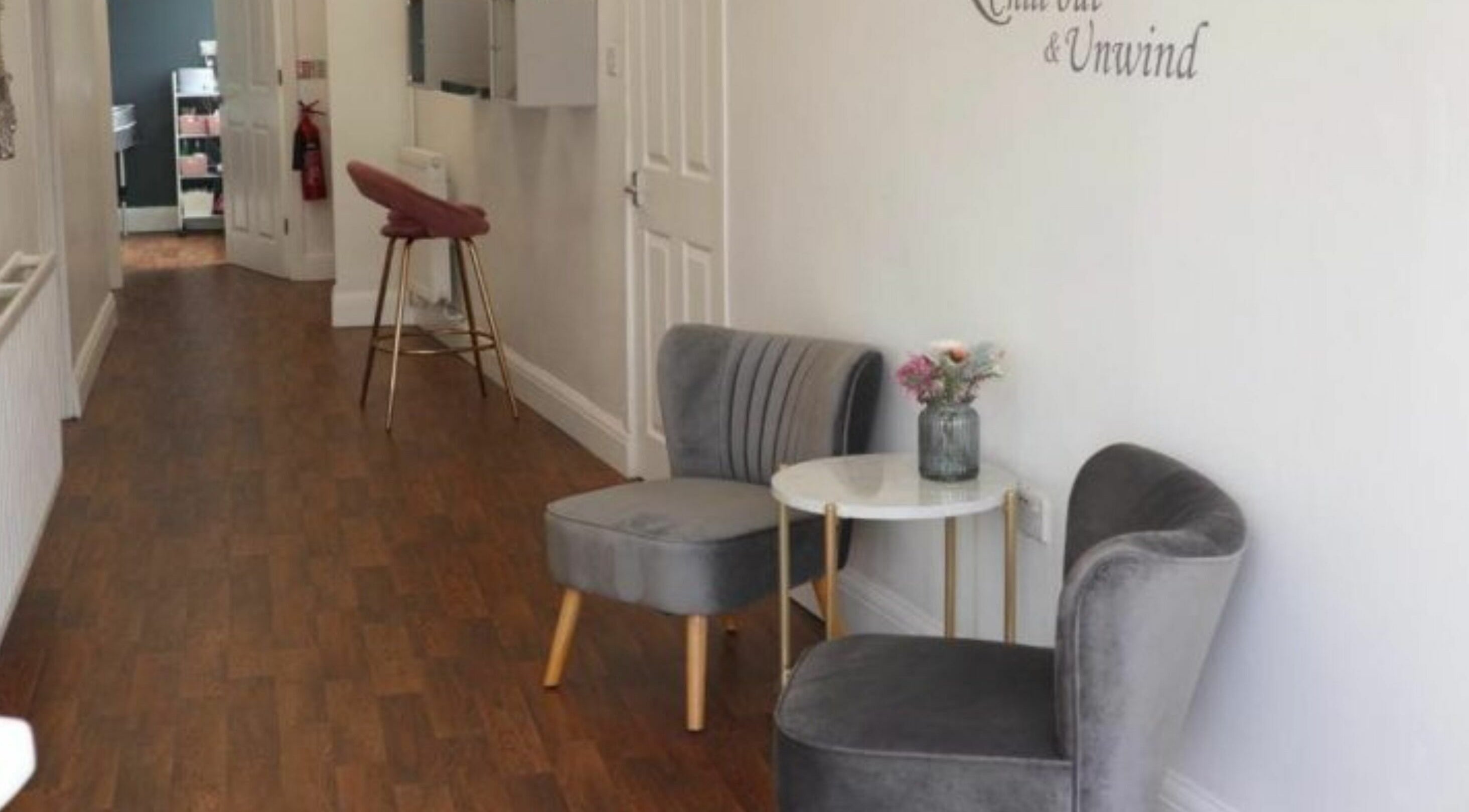 Stylish waiting area of Inspire Hair, Nottingham, England, GB with cozy chairs and a table.