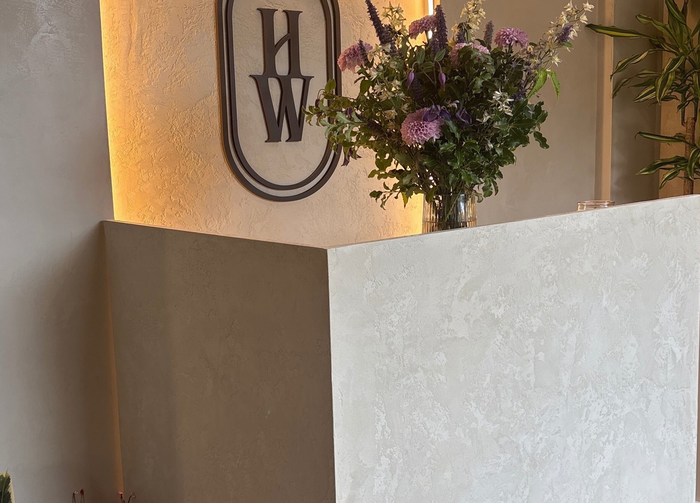 Reception desk with floral display at Hygge Well, Otley, England, GB.