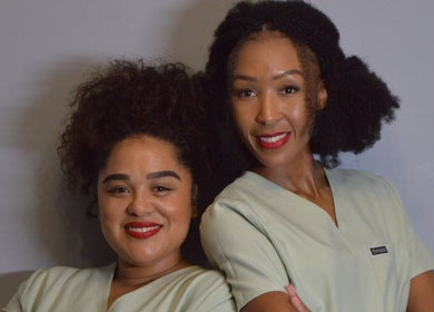 Two smiling staff members at Rsg Aesthetics, Cape Town, Western Cape, ZA, showcasing their uniform.