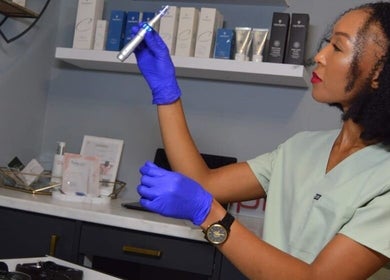 Technician at RSG Aesthetics, Cape Town, examines a device with precision in a modern treatment room.