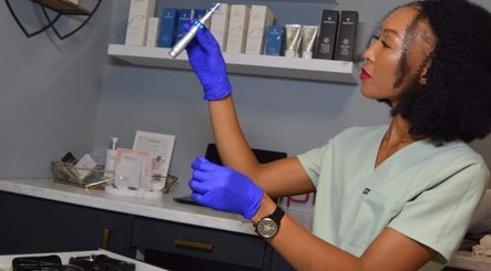 Technician at RSG Aesthetics, Cape Town, examines a device with precision in a modern treatment room.