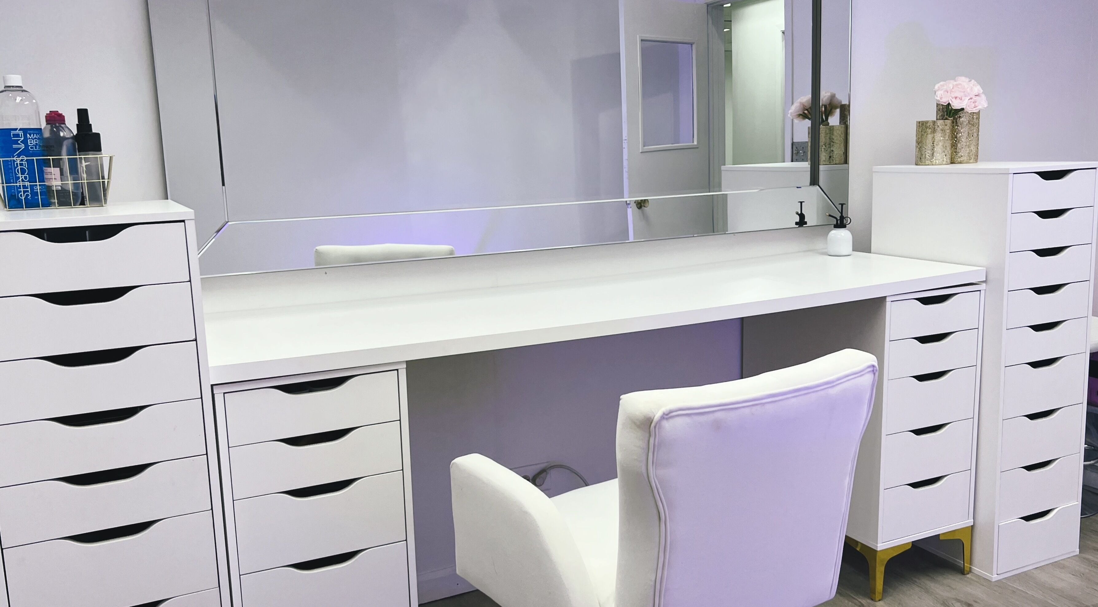 A chic vanity setup at Yuri Rangel Beauty Studio, Elgin, Illinois, US with a white chair and mirror.