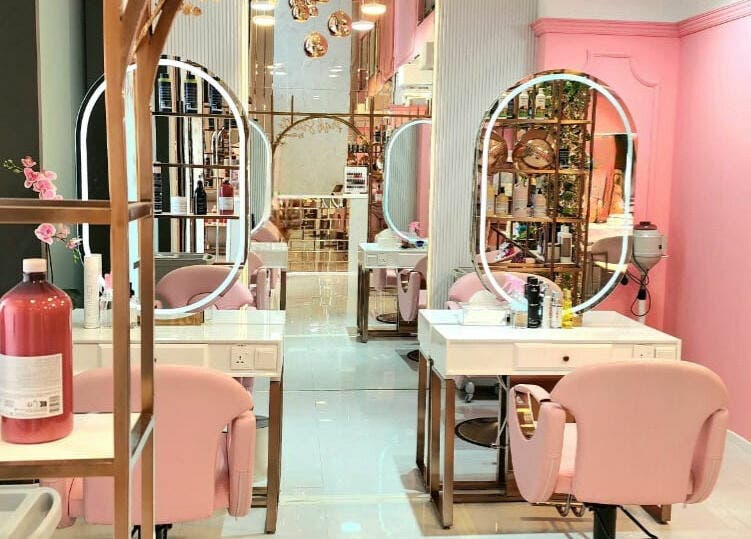 Elegant salon interior at Pink Stiletto by Shweta, Dubai. Soft pink chairs and mirrors enhance the beauty atmosphere.