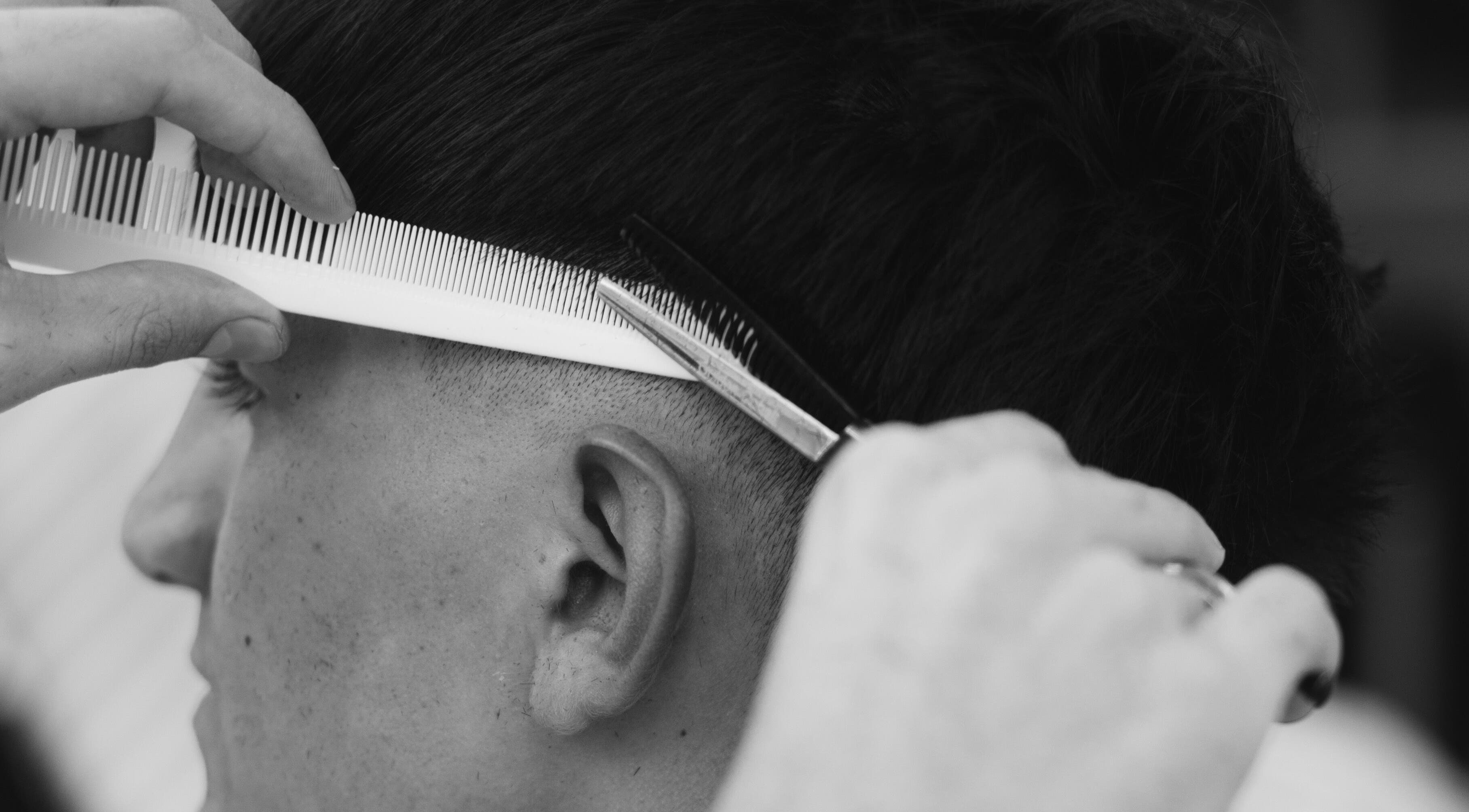 Corte de cabello en Vision Hair Studio, Rosario, Santa Fe, AR, mostrando técnica precisa con peine y tijera.