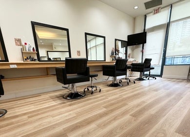Spacious interior of CuE Hair Salon Vancouver with modern chairs and mirrors, located in Vancouver, British Columbia, CA.